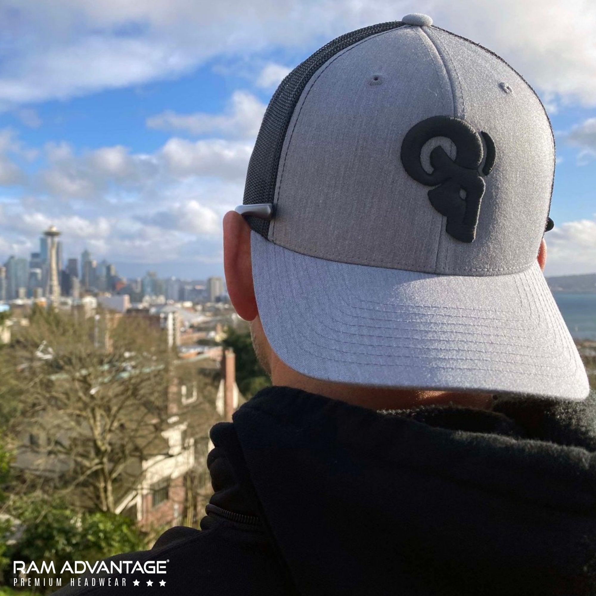 BRANDON DINOVI wearing a RAM ADVANTAGE premium HEATHER GREY and BLACK 3D embroidered TRUCKER HAT overlooking the SEATTLE  skyline